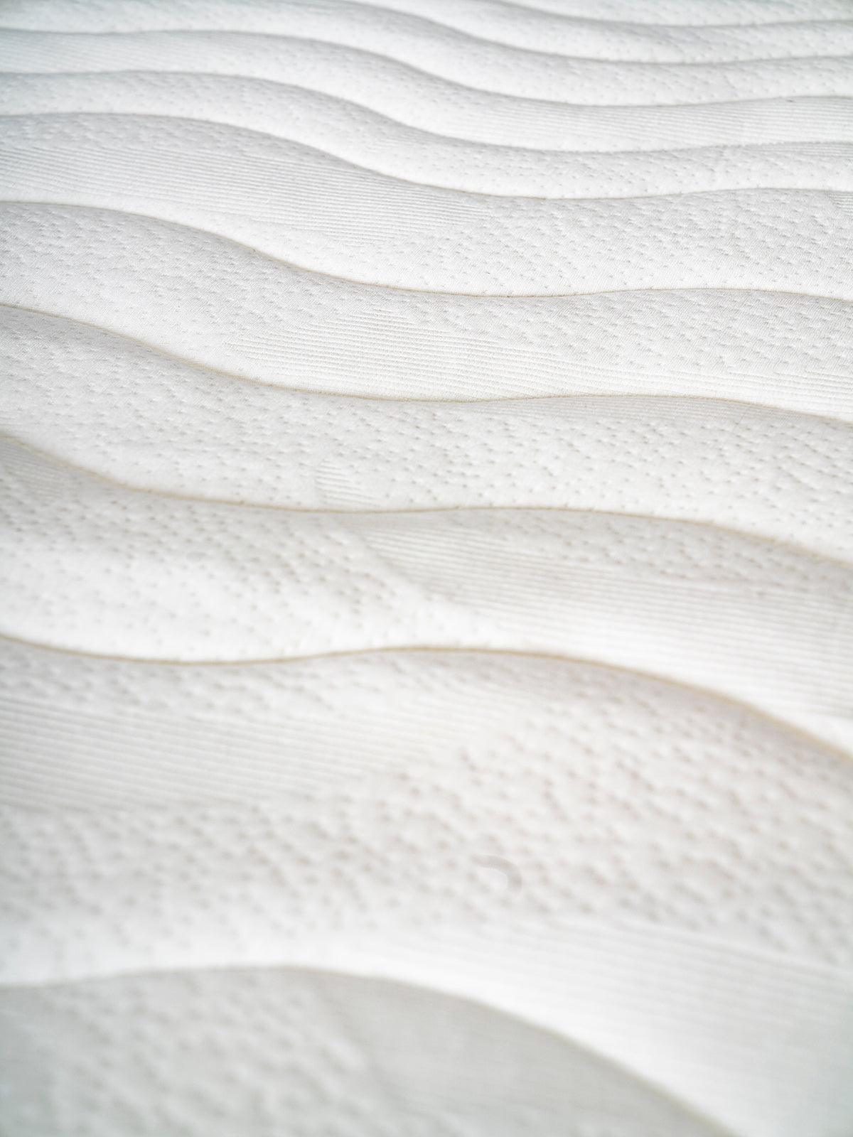 Close-up of the textured surface of the Topper 3.0 orthopedic mattress pad, designed for added firmness and comfort.